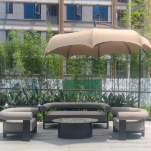 Beige fabric cantilever umbrella shading gray curved sofa and matching armchairs in landscaped courtyard